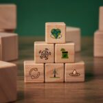 Wooden blocks stacked in a pyramid shape display eco-friendly icons, such as a globe, recycling symbol, and a leaf. The tone is clean and sustainable